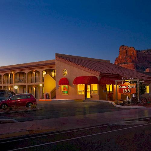 The image shows an illuminated inn with a sign reading 